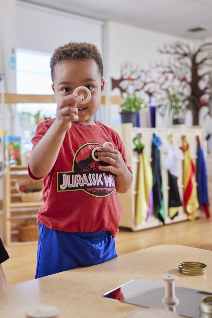 Young boy playing with small wooden circle toys